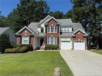Charming two-story home with a well-manicured lawn, mature trees, and a two-car garage at 399 Falling Water Rd, Spring Lake, NC 28390