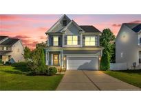 Charming two-story home with a gray exterior, well-maintained lawn, and inviting curb appeal at 786 Century Dr, Cameron, NC 28326