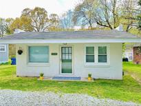 Charming, white single-story home featuring a well-kept lawn, quaint decorations, and bright natural lighting at 1113 Midland Ter, Durham, NC 27704