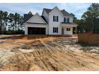 New construction home with white siding and an attached two-car garage, surrounded by a yard under construction at 298 Dove Rd, Cameron, NC 28326