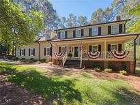 Charming two-story home featuring a welcoming front porch with decorative bunting and a well-maintained lawn at 3103 Royal Pine Dr, Sanford, NC 27330