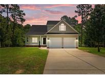 Charming two-story home with a two-car garage, lush lawn, and beautiful landscaping, perfect for Gathering living at 35 Pineridge Cv, Sanford, NC 27332