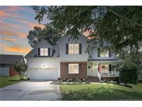 Charming two-story home features a well-manicured lawn, brick accents, inviting front porch, and attached two-car garage at 43 Ambrose Pt, Cameron, NC 28326