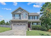 Charming two-story home with stone accents, attached two-car garage, and well-maintained lawn at 442 Kentucky Derby Ln, Lillington, NC 27546