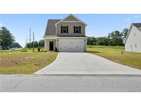 Charming two-story home featuring a concrete driveway, light beige siding, and a convenient attached garage at 15 Red Bird Dr, Cameron, NC 28326