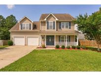 Charming two-story home featuring a well-manicured lawn and a two-car garage in a suburban neighborhood at 280 Hillandale Rd, Spring Lake, NC 28390