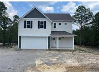 Charming two-story home featuring white siding, black shutters, and an attached two-car garage at 138 Travelers Way, Lillington, NC 27546