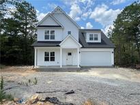 Charming two-story white home with a classic design, attached garage, and inviting front entrance at 151 Travelers Way, Lillington, NC 27546