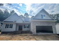 New construction home with stone accents, attached garage, and covered front porch at 27 Lookout Pt, Sanford, NC 27332