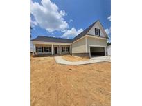 Charming single-story home with a two-car garage, covered entry, and a well-manicured lawn under a blue sky at 46 Poplar Dr, Spring Lake, NC 28390