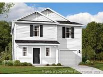 Charming two-story home with a modern design, featuring a one-car garage and manicured landscaping at 560 Stadium Drive, Cameron, NC 28326