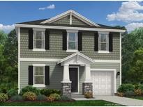 Charming two-story home featuring a classic design, a one-car garage, and a beautifully landscaped front yard at 566 Stadium Drive, Cameron, NC 28326