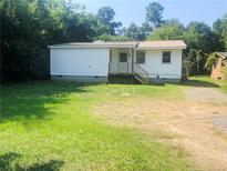 Charming single-story home with white siding and a metal roof, surrounded by a green lawn at 644 Moores Chapel Rd, Lillington, NC 27546