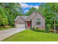 Charming home featuring a well-manicured lawn, red front door, and attached two-car garage at 125 Lakeforest Trl, Sanford, NC