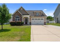 Charming home featuring stone accents, manicured lawn, and a two-car garage at 220 Trenton Pl, Cameron, NC 28326