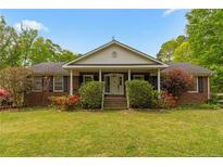 Charming brick ranch with a cozy front porch, black shutters, and a well-manicured lawn at 9301 Nc 27, Lillington, NC 27546