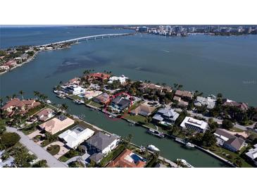 Aerial view of waterfront home with private dock and lush landscaping at 414 Meadow Lark Dr, Sarasota, FL 34236