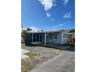 Mobile home with screened porch and gravel driveway at 2601 Gulf N Dr # 603, Bradenton Beach, FL 34217