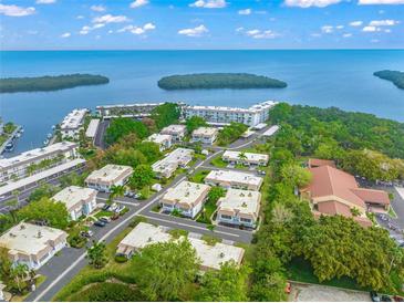 Aerial view of waterfront community with lush landscaping and multiple buildings at 542 Sutton Pl, Longboat Key, FL 34228