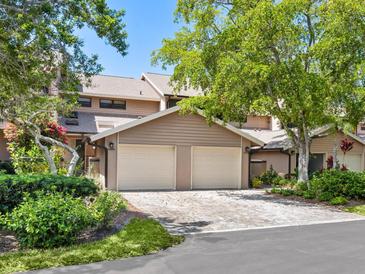 Tan two-story condo with a two-car garage and landscaped grounds at 5228 Landings Blvd # 202, Sarasota, FL 34231