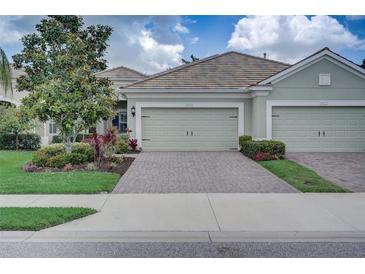 House exterior featuring a two-car garage and well-maintained landscaping at 4826 Maymont Park Cir, Bradenton, FL 34203