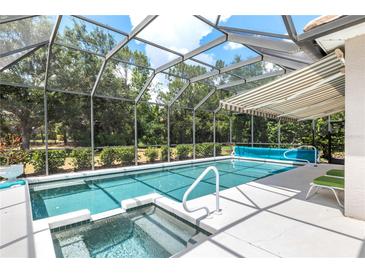 A luxurious pool and hot tub is encased by a screened enclosure offering seamless indoor-outdoor living at 7249 Orchid Island Pl, Bradenton, FL 34202