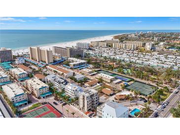 Aerial view of beachfront community, tennis courts, and pool at 1150 Windsong Ln # 400, Sarasota, FL 34242