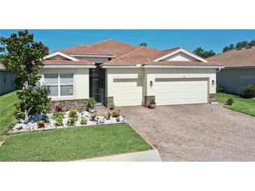 Charming single-story home featuring a well-manicured lawn, paver driveway, and a beautiful tile roof at 1934 Mesic Hammock Way, Venice, FL 34292