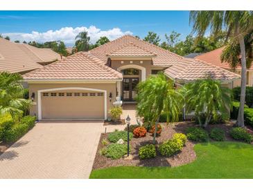 Charming single-story home featuring a tile roof, landscaped yard and brick-paved driveway at 7167 Whitemarsh Cir, Lakewood Ranch, FL 34202