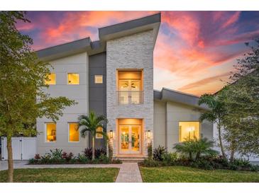 Stunning modern home with light stone and gray exterior at sunset at 2446 Floyd St, Sarasota, FL 34239