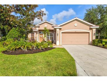 Charming single-story home with a well-manicured lawn, beautiful landscaping, and a two-car garage at 105 New Briton Ct, Bradenton, FL 34212