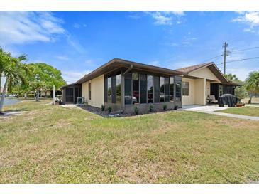 Tan single-story home with sunroom and grassy yard at 4109 66Th Street W Cir # 4109, Bradenton, FL 34209