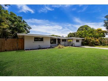 Ranch style home with a well-manicured lawn and wood fence at 2216 Lee Ln, Sarasota, FL 34231