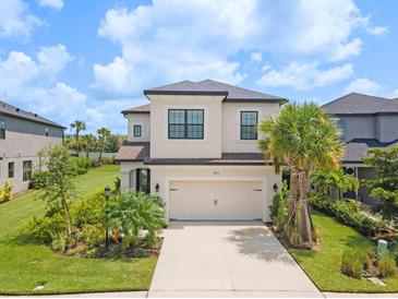 Two-story house with beige exterior, landscaping, and a two-car garage at 8370 Velda Trl, Sarasota, FL 34241