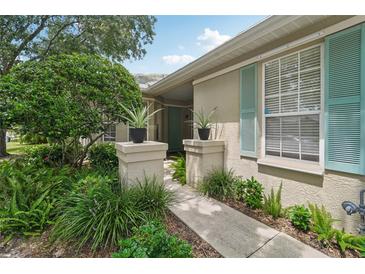 Inviting front entrance with landscaping and teal shutters at 4951 Lakescene Pl, Sarasota, FL 34243