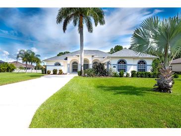 Beautiful single-story home with a three-car garage and lush landscaping at 15923 29Th E St, Parrish, FL 34219