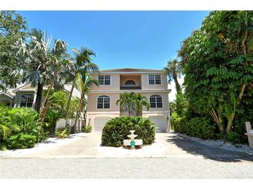 Two-story house with a light peach exterior, two-car garage, and landscaping at 4931 Oxford Dr, Sarasota, FL 34242