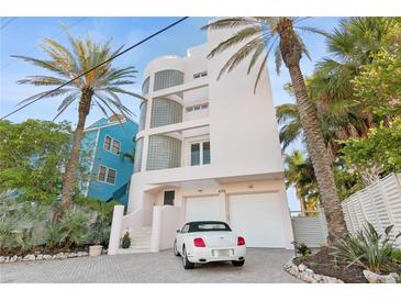 Three-story house with white walls, glass block accents, and a two-car garage at 648 Beach Rd, Sarasota, FL 34242