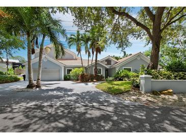 Gray house with palm trees, driveway, and landscaped yard at 1400 Quail Dr, Sarasota, FL 34231