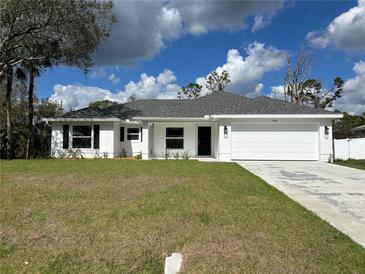 A charming single-story home boasts a well-maintained lawn and a classic two-car garage for modern living at 2968 Yacolt Ave, North Port, FL 34286