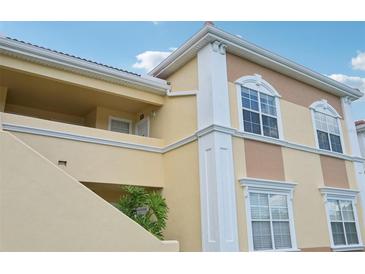 Tan building with white trim, balconies, and stairs, offering a charming exterior at 1050 Villagio Cir # 206, Sarasota, FL 34237