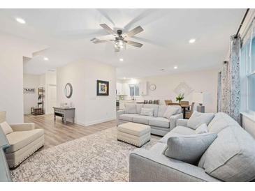 Spacious living room featuring a comfortable seating area and hardwood floors at 11868 Little River Way, Parrish, FL 34219