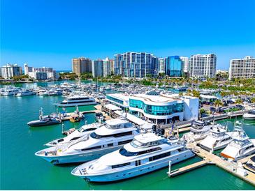 Aerial view of a waterfront community with luxury yachts and high rise buildings at 1155 N Gulfstream Ave # 208, Sarasota, FL 34236