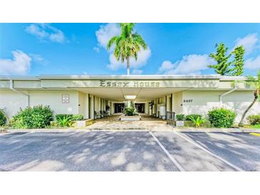 Essex House building exterior, featuring a covered entryway and landscaping at 2437 Harbor Blvd # 204, Port Charlotte, FL 33952