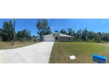 Newly constructed home with a paved driveway and spacious lawn at 1702 Rada Ln, North Port, FL 34288