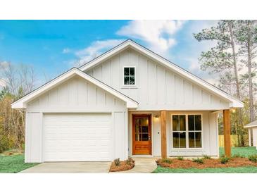 White farmhouse-style home with brown door and wooden posts at 813 39Th W St, Bradenton, FL 34205