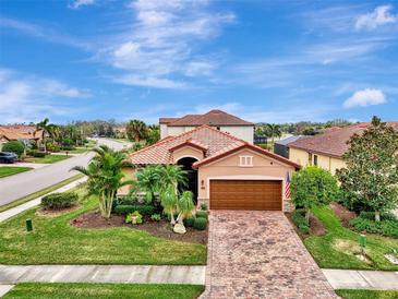 Single-story home with brown garage door, landscaping, and brick driveway at 135 Sweet Tree St, Bradenton, FL 34212