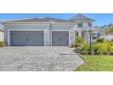 Two-story home with gray double garage and paver driveway at 21285 Holmes Cir, Venice, FL 34293