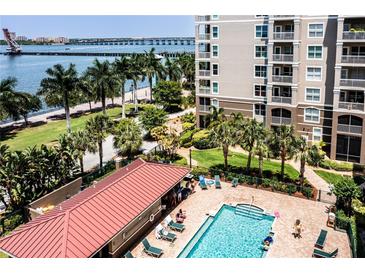 Community pool with lounge chairs and surrounding landscaping at 808 3Rd W Ave # 701, Bradenton, FL 34205