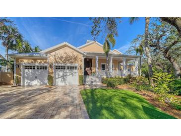 Two-story house with a light-yellow exterior, two-car garage, and a landscaped lawn at 5309 Hidden Harbor Rd, Sarasota, FL 34242
